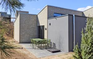 a patio with a table and chairs in front of a building at Cozy Home In Lembruchdümmer See in Lembruch