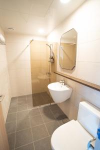 een badkamer met een wastafel, een toilet en een spiegel bij Seaore Resort in Seogwipo