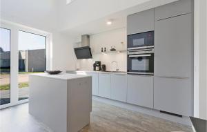 a white kitchen with white cabinets and appliances at Nice Home In Lembruchdümmer See in Lembruch
