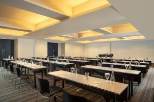 a large dining room with tables and chairs at ARTOTEL TS Suites Surabaya in Surabaya