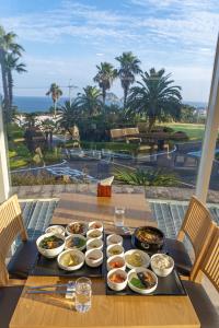 een tafel met borden met voedsel erop met uitzicht op de oceaan bij Seaore Resort in Seogwipo