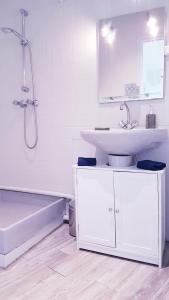 a white bathroom with a sink and a bath tub at Appartement F2 centre-ville ISSOIRE avec jolie vue in Issoire