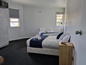 1 dormitorio con 1 cama grande y 2 ventanas en Parkes Hotel, en Parkes