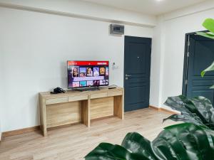 GP House Bangkok - Sukhumvit Onnut BTS Skytrain في بانكوك: غرفة معيشة مع تلفزيون على طاولة خشبية
