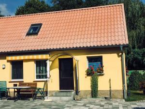 a yellow house with an orange roof and a table at Luzie's Hus in Freest
