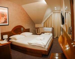 a bedroom with a bed with white sheets and pillows at Hotel Laktaši in Laktaši