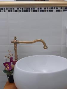 a bathroom with a white sink and a faucet at PENSIUNEA Bori in Gura Humorului