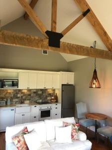 a living room with a white couch and a kitchen at River View Cottage in Kahuranaki