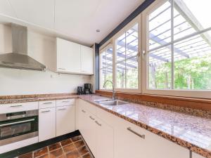 une cuisine avec des placards blancs et une grande fenêtre dans l'établissement Beautiful holiday home in Lochem with garden, à Lochem