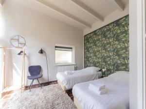 - une chambre avec deux lits et une chaise bleue dans l'établissement Beautiful holiday home in Lochem with garden, à Lochem