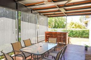 a patio with a table and chairs on a deck at Mooney St Manor in Aitkenvale