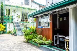 a building with a table and plants in front of it at Kandy Riverside Villa in Kandy