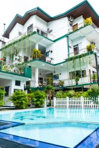 a building with a swimming pool in front of a building at Kandy Riverside Villa in Kandy
