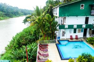 a hotel with a swimming pool next to a river at Kandy Riverside Villa in Kandy
