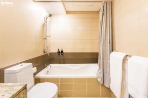 a bathroom with a tub and a toilet at bnbmehomes - Duplex Living walk to Burj K and Dubai Mall - L313 in Dubai