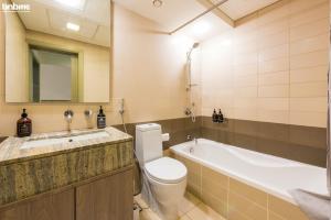 a bathroom with a tub and a toilet and a sink at bnbmehomes - Duplex Living walk to Burj K and Dubai Mall - L313 in Dubai