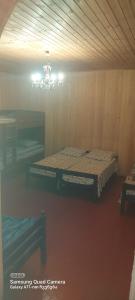 Cette chambre comprend deux lits et un lustre. dans l'établissement Guest House Sabauri, à Kazbegi