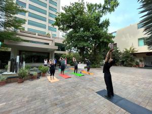 un grupo de personas haciendo yoga frente a un edificio en Boulevard 9 Luxury Resort & Spa, en Nadiād