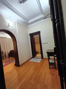 an empty room with a wooden floor and a door at Al Khariss Hotel in Doha