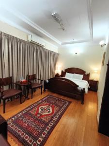 a bedroom with a large bed and a rug at Al Khariss Hotel in Doha