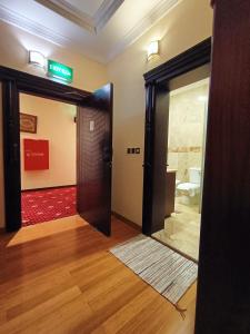 an open door in a room with a sign on the wall at Al Khariss Hotel in Doha