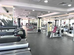 a gym with a lot of treadmills and machines at SeaBreeze Apartment - Beachfront & Sea View Al Hamra in Ras al Khaimah