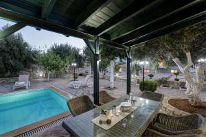 eine Terrasse mit einem Tisch und einem Pool in der Unterkunft Marakis Villas in Kavrokhórion