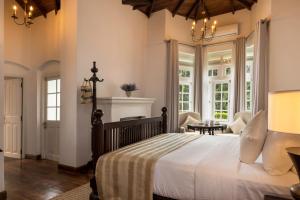 a bedroom with a large bed and a dining room at The Lavender House by Reveal in Kandy