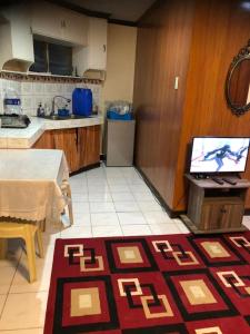 uma cozinha com uma mesa e uma televisão num balcão em THE MANSION - 24-HOUR Near AirPort Hostel 4 Backpackers em Manila