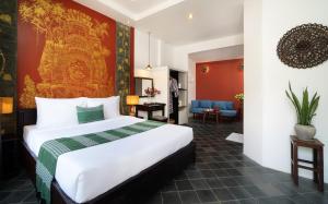 um quarto de hotel com uma cama grande num quarto em The Urban em Siem Reap