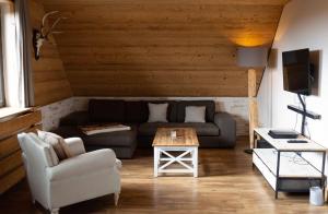 ein Wohnzimmer mit einem Sofa und einem Tisch in der Unterkunft StrandBerg's Harzchalet in Braunlage
