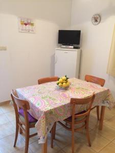a dining room table with a bowl of fruit on it at Apartment in Slatine with terrace, air conditioning, WiFi, washing machine (4782-3) in Slatine