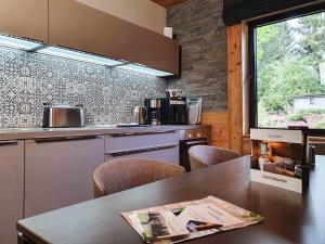 eine Küche mit einem Tisch und Stühlen sowie einem Fenster in der Unterkunft StrandBerg's Harzchalet in Braunlage