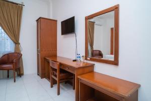 a bathroom with a wooden desk and a mirror at RedDoorz Plus at Hotel Surya Solo in Solo