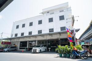un edificio blanco con coches estacionados frente a él en RedDoorz Plus at Hotel Surya Solo en Solo