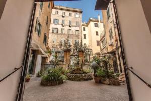 un espejo reflejo de un callejón con edificios y plantas en Suites by Chloe, en Roma