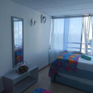 um quarto com uma cama e uma grande janela em Excelente vista al mar em Cartagena das Índias