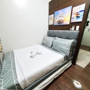 a bedroom with a bed with white sheets and pillows at Netflix all day in Lovely 1BR with Balcony Condo AIR Residences in Manila