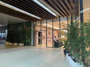 an empty lobby with potted plants in a building at Netflix all day in Lovely 1BR with Balcony Condo AIR Residences in Manila