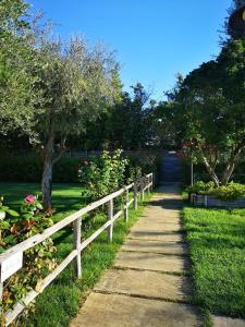 um caminho num parque ao lado de uma cerca em Montenovo Country House em Ostra Vetere