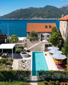 a swimming pool with umbrellas and the water at Villa Lastva in Tivat