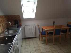 a kitchen with a table and chairs and a sink at Ferienwohnung StrandGut in Burhave +4 photos