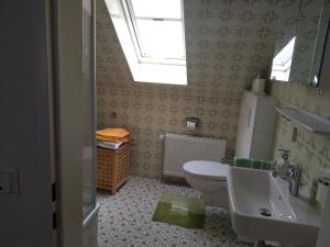 a bathroom with a sink and a toilet and a window at Ferienwohnung StrandGut in Burhave