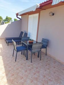 a patio with chairs and a table on a house at Apartment in Mundanije with balcony, air conditioning, WiFi (4912-1) in Mundanije