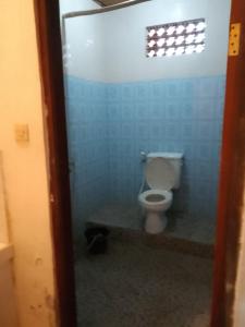 a bathroom with a toilet in a blue wall at Tunjung Guest House in Ubud