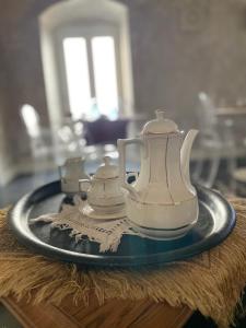 zestaw do parzenia herbaty na talerzu na stole w obiekcie Palazzo Siena De Facendis w mieście Bitonto