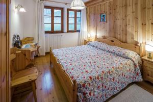 um quarto com uma cama e paredes e pisos em madeira em Villa Marianna - Stayincortina em Cortina dʼAmpezzo