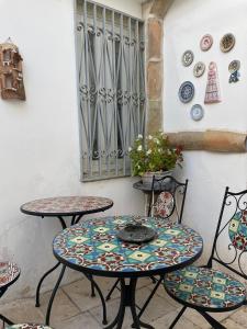 dwa stoły i krzesła z płytami na ścianie w obiekcie Palazzo Siena De Facendis w mieście Bitonto