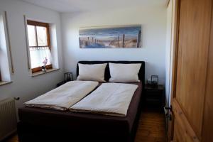 a bed in a bedroom with a painting on the wall at Ferienwohnung Amboss in Grünkraut