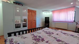 a bedroom with a bed with a floral bedspread on it at DARIAMAF in Câmpulung Moldovenesc